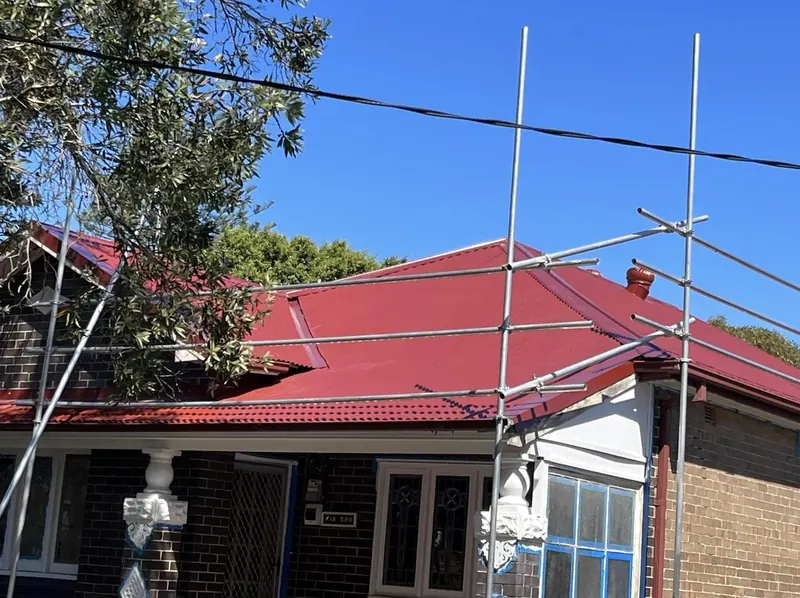 Botany roof repair: red metal roof under scaffolding