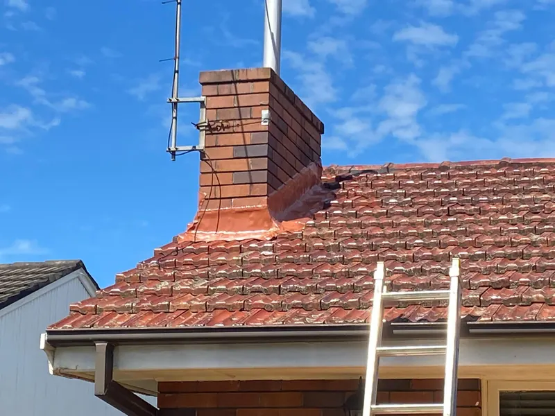 Terracotta tile roof and chimney flashing after repairs