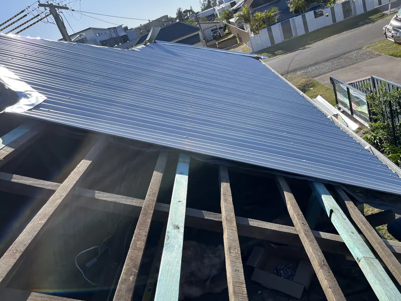 Metal roof sheet laid over new battens on a cottage re-roof