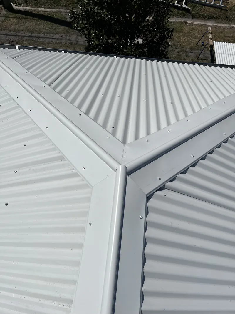 Ridge and hip capping on a new white metal roof