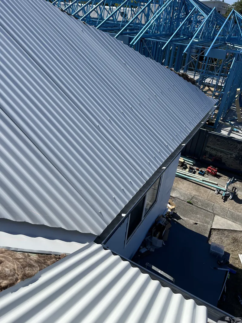 Edge of a new corrugated roof sheet over the old frame