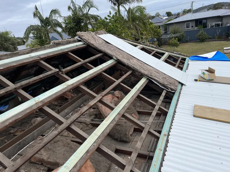 Old tiles stripped back to the timber frame before re-roofing