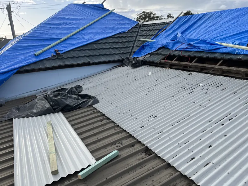Partly re-roofed house with tarps protecting the open section