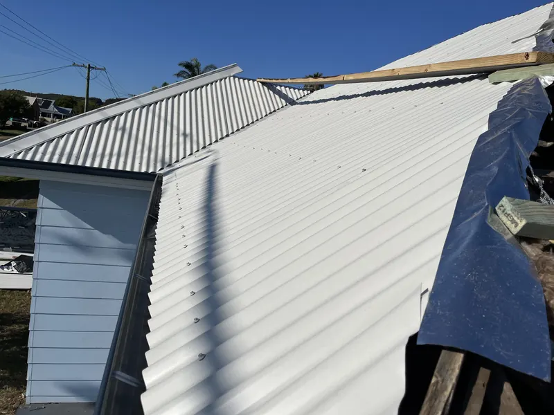 New metal roof valley being formed on a cottage re-roof