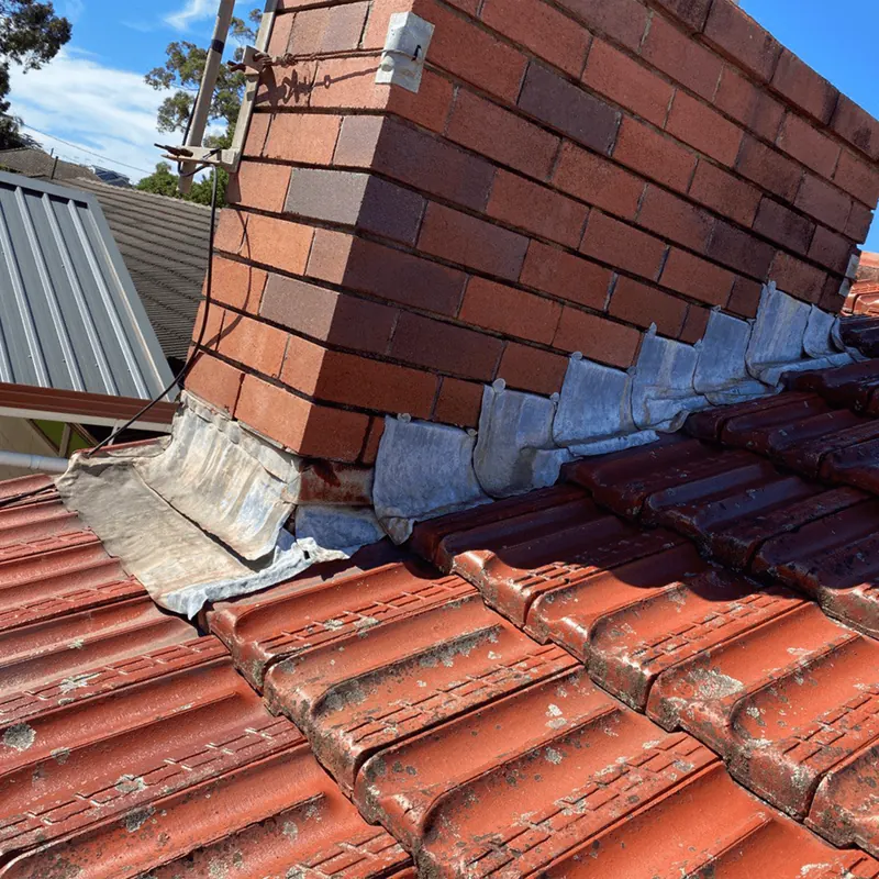 Chimney flashing on a terracotta tile roof