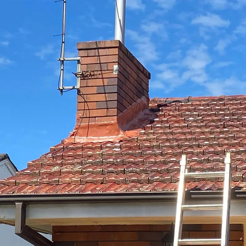Chimney and tile roof with new flashing