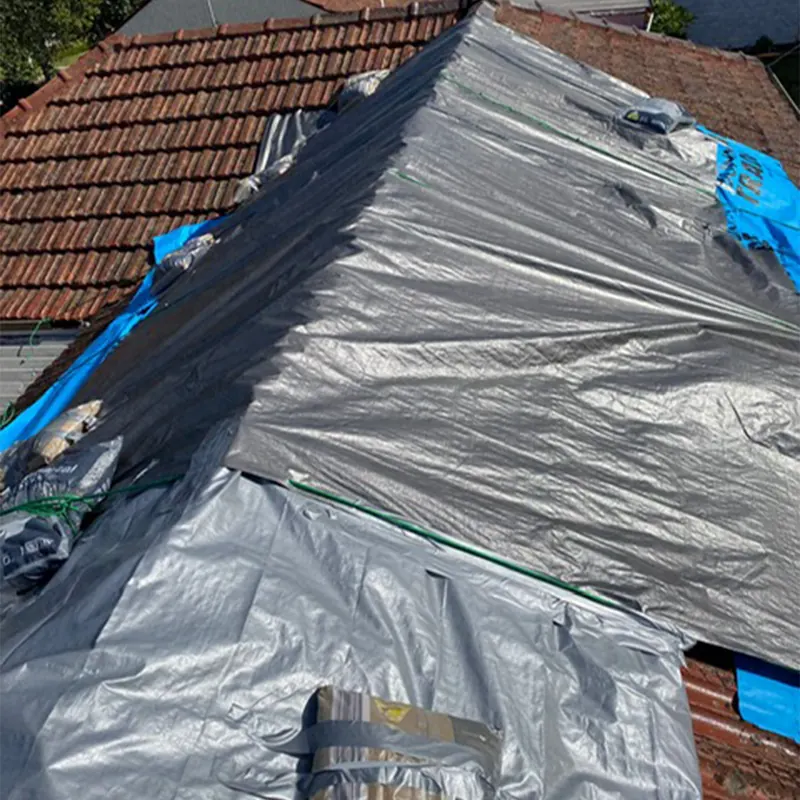 Plastic sheeting protecting a damaged roof section