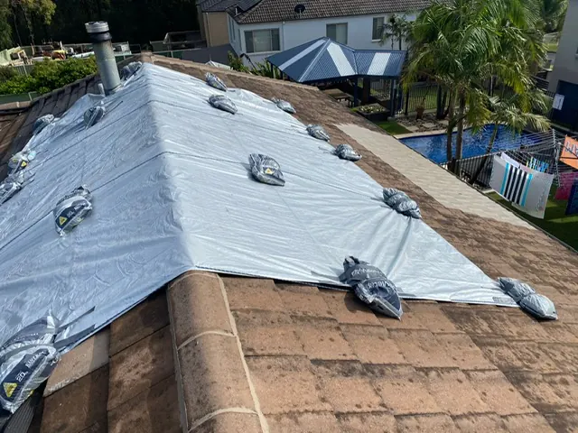 Temporary roof cover held down with weights