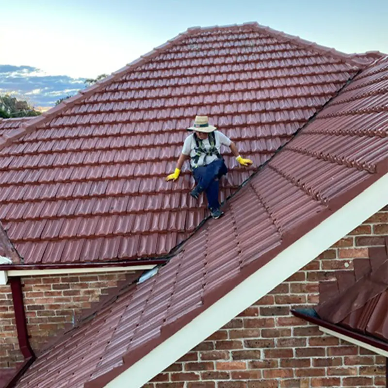 Roofer working on a two-storey tile roof