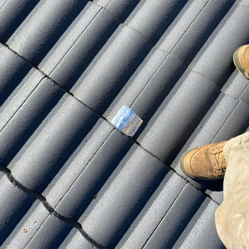 Cracked roof tile with a temporary patch