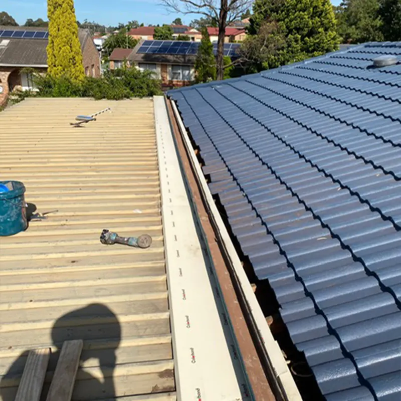 New metal roof sheets beside old roof tiles